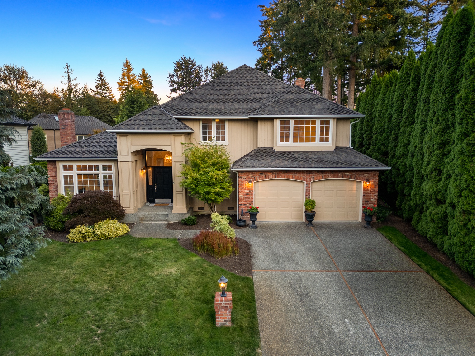 Two-story brick and tan colonial home exterior at twilight